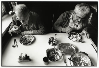 107964 Afbeelding van twee thuisloze mannen tijdens het diner in de gemeenschappelijke ruimte van het maatschappelijk ...